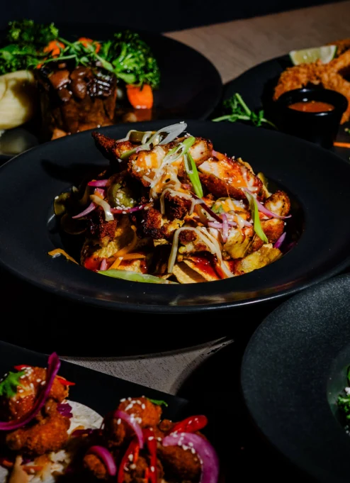A warm family meal in a cosy restaurant setting with a variety of vibrant dishes.