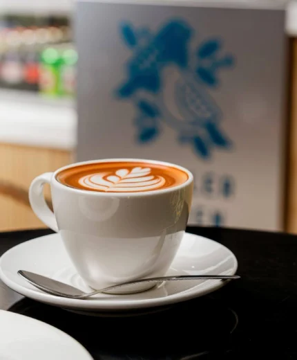 A warm latte and croissant in a cosy café setting, perfect for hotel guests.