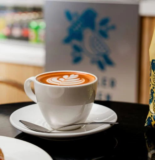 A warm latte and croissant in a cosy café setting, perfect for hotel guests.