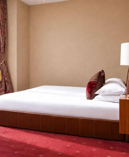 Cosy hotel room with large window and comfortable bed.