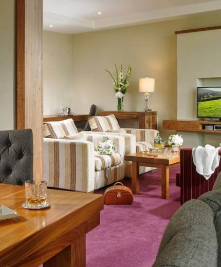 Elegant hotel suite with cosy seating and warm lighting.
