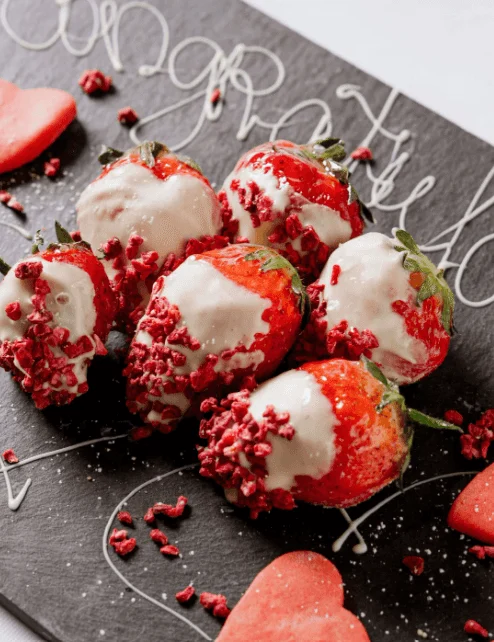 Strawberries and heart cookies on a tray with "Congratulations" written in icing.